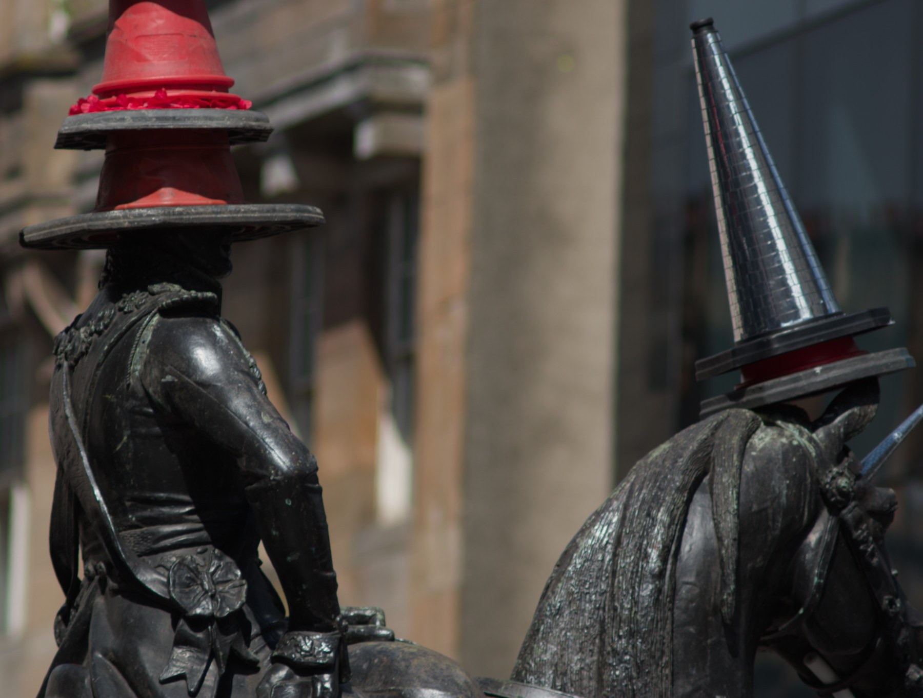 Close-up of the equestrian Duke of Wellington statue in Glasgow city centre, with traffic cones balanced on the rider’s head and the horse’s head.